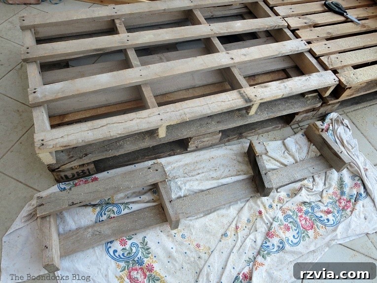 Super Simple Pallet Couch No Tools Needed 5 Carefully cutting the one extra wide pallet with a hand saw to achieve a uniform couch backrest.