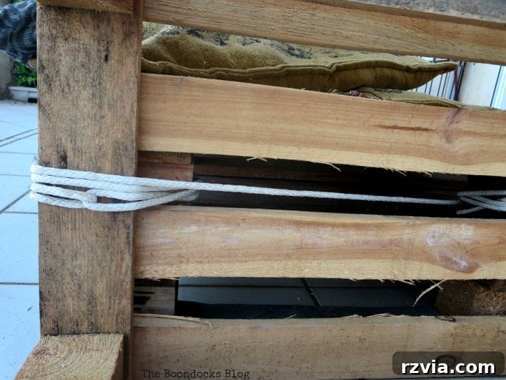 Super Simple Pallet Couch No Tools Needed 8 Continuing the rope-tying process across the pallets, securing multiple connection points for enhanced stability.
