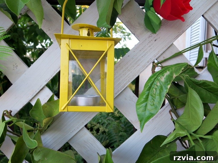 Budget Blooms: Brighten Your Fence 12 A charming yellow tea light lantern hanging gracefully on the finished lattice flower wall, adding warmth and ambiance.