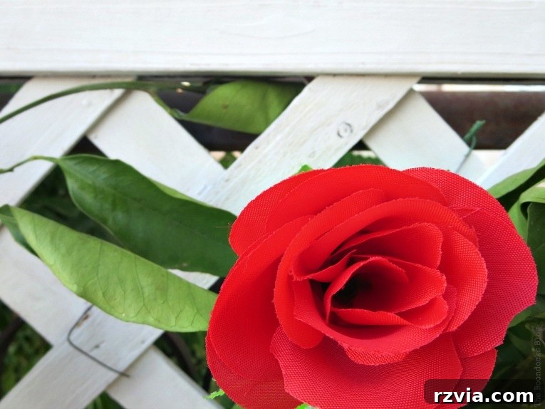 Budget Blooms: Brighten Your Fence 14 A close-up view of a beautifully crafted faux red rose, demonstrating its realistic appearance and texture.