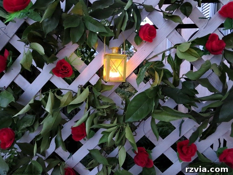 Budget Blooms: Brighten Your Fence 17 A close-up view of the lit tea light lantern nestled within the lattice flower wall, radiating a soft, inviting glow.