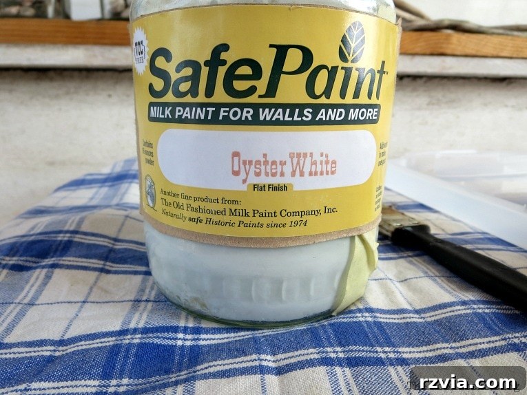 Budget Blooms: Brighten Your Fence 5 A can of Old Fashioned Milk Paint in Oyster White, ready to transform the lattice panel.