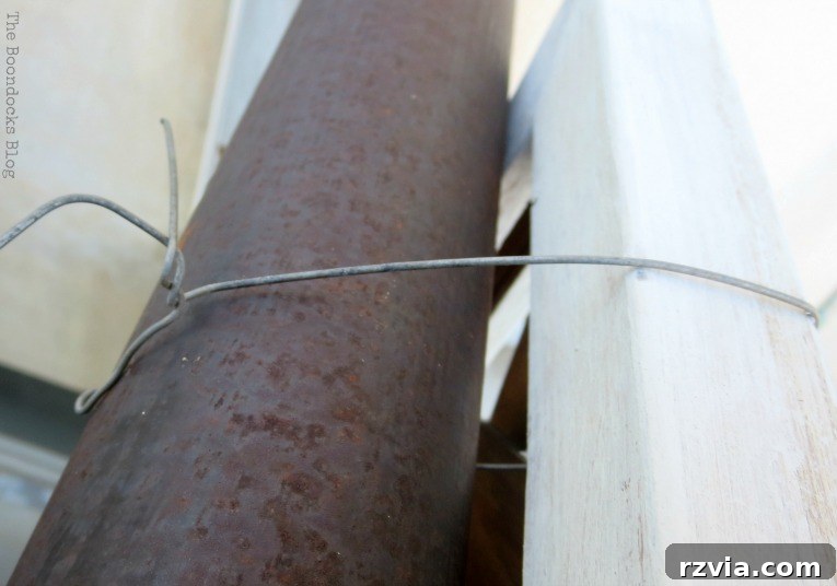 Budget Blooms: Brighten Your Fence 8 Securing the lattice flower wall panel to the balcony rail using thin wire for a stable and beautiful display.