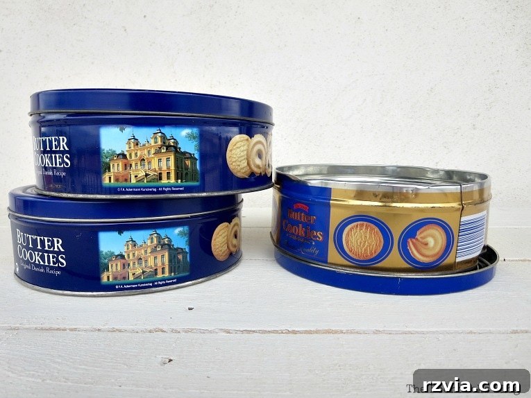 Fabric Makeovers for Cookie Tins 3 A collection of plain old cookie tins before their upcycled transformation with colorful fabric.