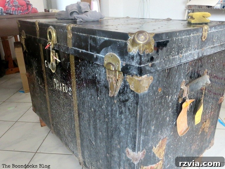 Aged to Perfection: Milk Painting a Vintage Metal Trunk 3 Before photo of a severely worn vintage metal trunk, showcasing its original distressed state before a DIY makeover.