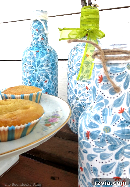 Three plastic bottles covered with pretty napkin paper using decoupage.