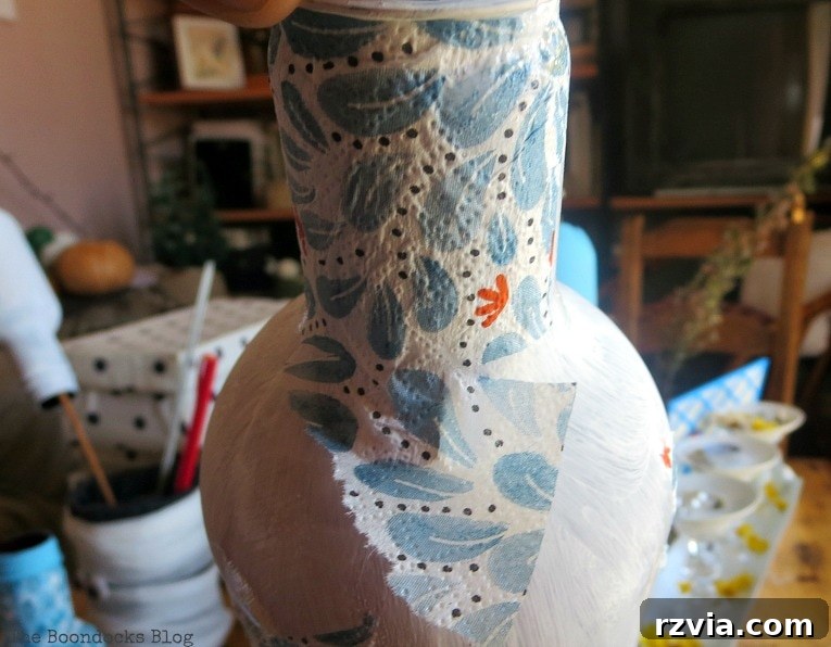 Decoupaging napkins on top of chalk painted plastic bottles, showing the careful application process.
