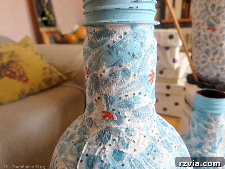 Close up showing that a napkin has rubbed off of the plastic bottle, illustrating a common decoupage mistake when not properly adhered or sealed.