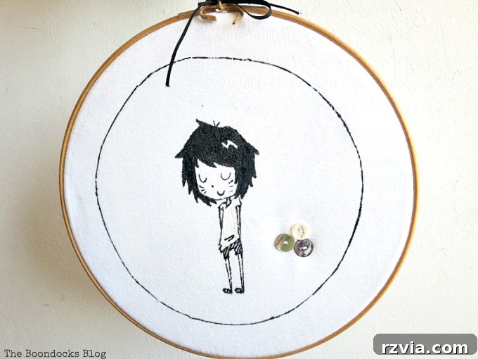 Upcycled T-shirt Wall Decor 2 upcycled tshirt placed into the embroidery hoop and hung on the wall, featuring a whimsical girl character design.