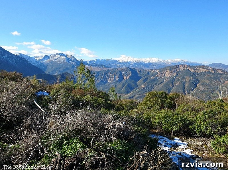 The White Crowns of Greece 2 Panoramic view of the snow-covered mountain range in Greece, showcasing the serene winter landscape and distant peaks. A perfect destination for winter travel in Greece.
