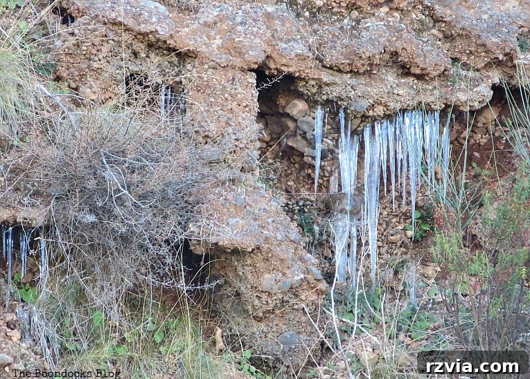 The White Crowns of Greece 3 Close-up of sparkling icicles hanging from a rock face, signifying the cold temperatures high in the snowy Greek mountains, ideal for winter photography.