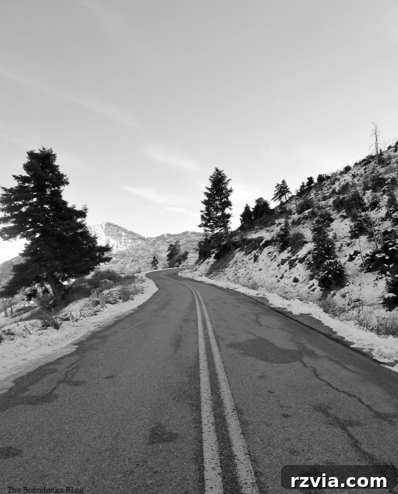 The White Crowns of Greece 21 The road leading back home through the snowy Greek mountains, reflecting the journey's end and the beautiful, serene winter scenery.