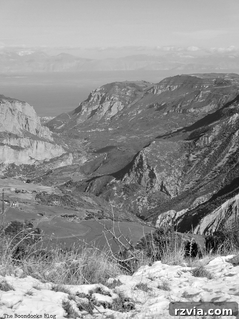 The White Crowns of Greece 22 Stunning black and white view from the snowy Greek mountains down to the majestic Corinthian Bay, highlighting dramatic contrasts and expansive landscape.