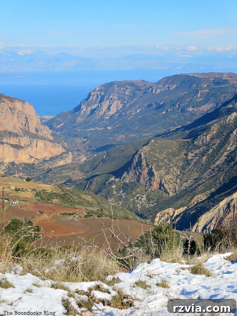 The White Crowns of Greece 23 Vibrant color view from the snowy Greek mountains overlooking the Corinthian Bay, showcasing the natural beauty and distant mountain ranges.