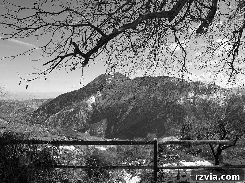 The White Crowns of Greece 10 Spectacular panoramic view looking down from the snowy Greek mountains, revealing distant valleys and a breathtaking expanse.