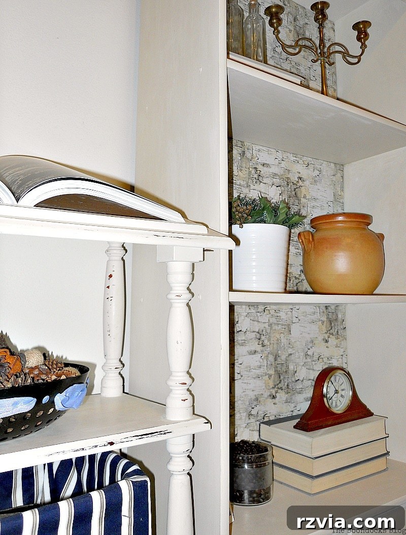 Paper and Paint Power: Bookcase Transformations 19 Distressed dictionary stand next to bookcase painted in white. Shelves are decorated with clay pot, flower pot, books, bottles and a clock.