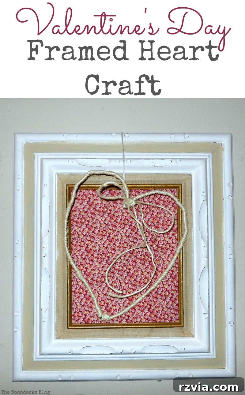 DIY Valentine Heart Frame 17 Wire heart wrapped in twine, elegantly hung over a frame covered with a red floral fabric, perfect for Valentine's Day decor
