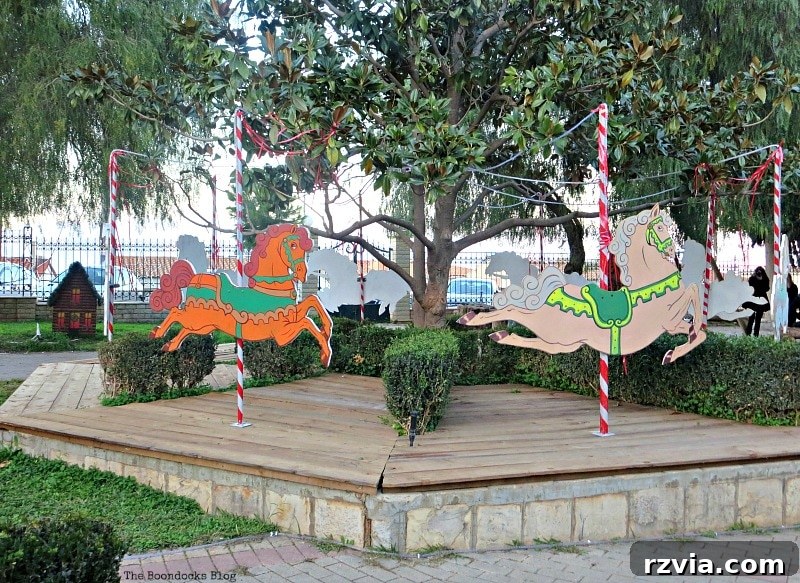 My Town's Best Kept Secrets 6 Brightly colored wooden horses in a festive Christmas park display