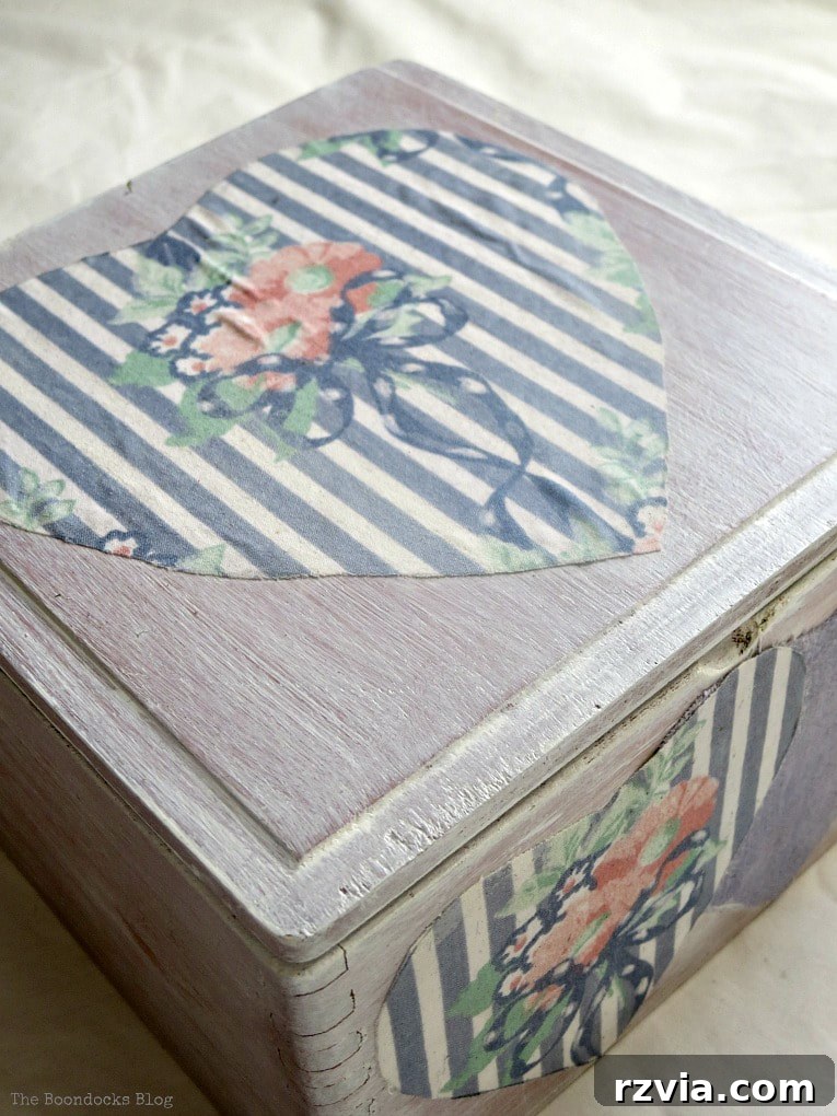 An old wooden cigar box, whitewashed and decoupaged with subtle hearts, now a versatile gift box