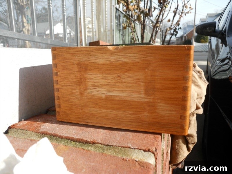 Old wooden cigar box showing stubborn glue residue after attempted removal, nicknamed 'glue hell'