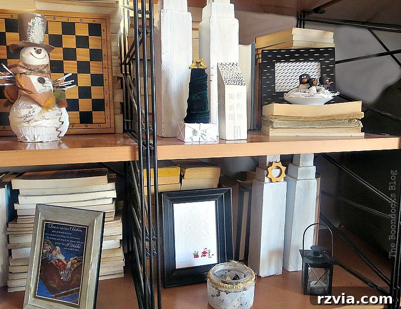 Wall unit shelves adorned with various repurposed decor items, including framed Christmas cards
