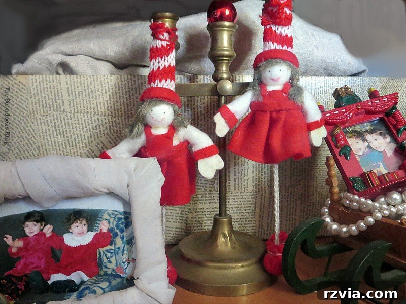 Picture frames displaying photos of children, alongside felt dolls, adding sentimental value