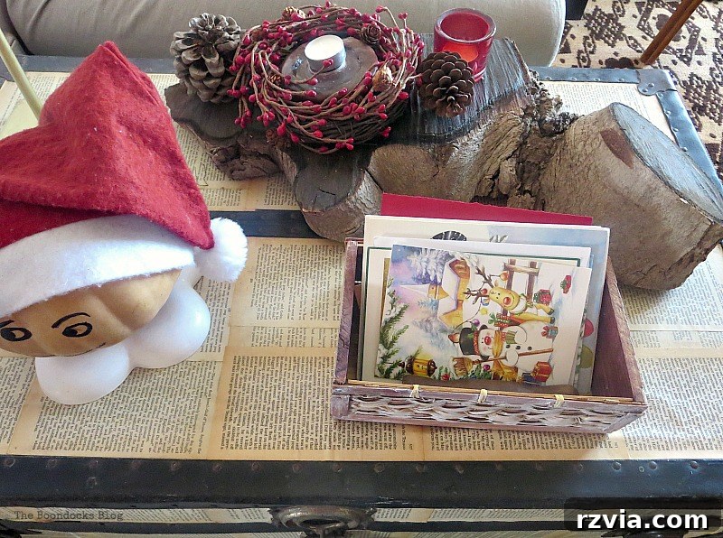 Decoupaged trunk adorned with a natural wood centerpiece and sentimental Christmas cards
