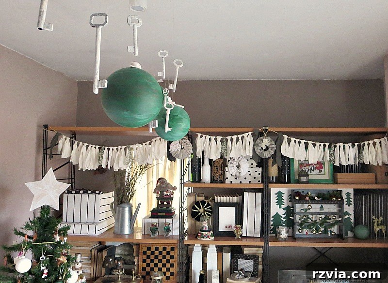 Ceiling spotlights adorned with painted green globes, showcasing repurposed Christmas decor