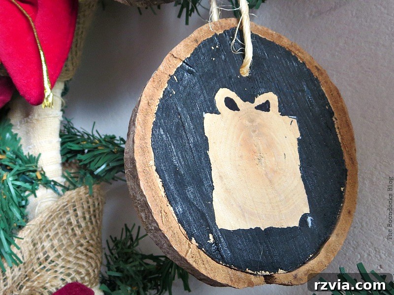 A decorative wood slice with a present design, symbolizing gifts