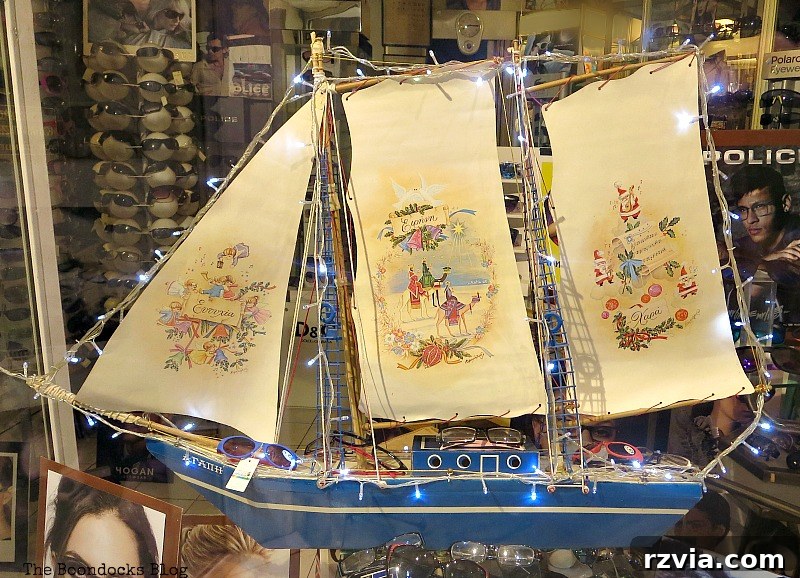 A beautifully illuminated sailboat displayed in a shop window for Christmas