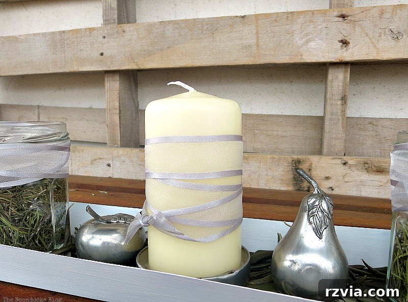 Close-up of the candle wrapped in a grey ribbon, a detail from the elegant Christmas centerpiece with metal accents, adding a subtle touch of sophistication. Photo by www.theboondocksblog.com