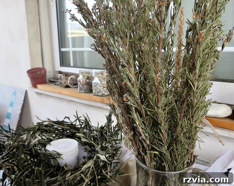 Dried rosemary branches in a glass pitcher, ready to be incorporated into the green Christmas centerpieces. Highlights the fresh, aromatic ingredient. Photo by www.theboondocksblog.com