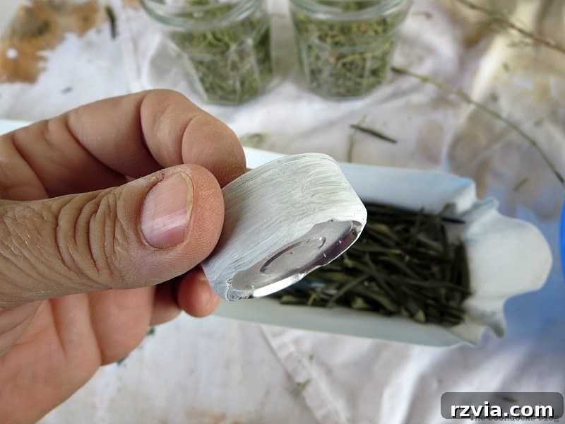 Painting small tea lights white to match the elegant green and white Christmas centerpiece theme. Demonstrates a simple DIY trick for a cohesive look. Photo by www.theboondocksblog.com