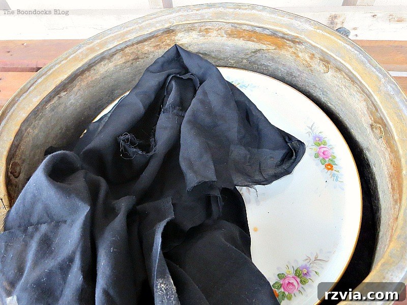 the cake stand placed inside the cauldron with a piece of fabric on top, A repurposed Antique Cauldron for Christmas theboondocksblog