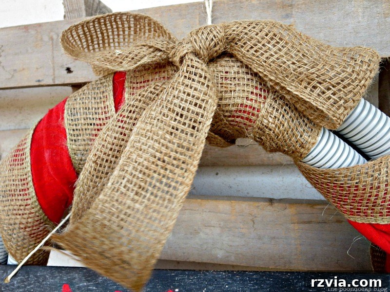 Close-up detail of the burlap ribbon intricately woven into the transformed tube wreath for a Christmas aesthetic.