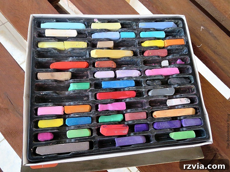 A box filled with various colored chalk sticks, ready for decorating the new DIY chalkboard signs.
