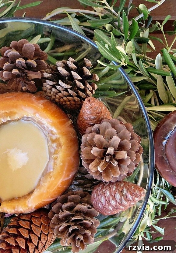 Autumn's Bounty for Your Table 2 Rustic Thanksgiving centerpiece featuring a candle, pinecones in a glass bowl, and encircled by fresh olive tree branches, set against a natural wood base.