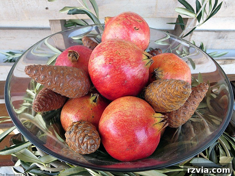 Autumn's Bounty for Your Table 11 Overhead view of the glass bowl, brimming with a festive arrangement of pomegranates and pinecones, showcasing their rich textures and colors.