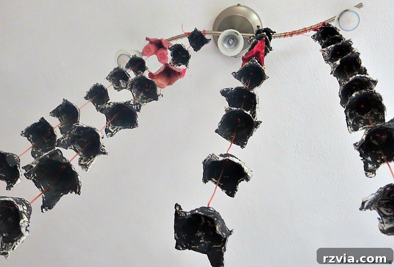 Repurposed black egg cartons, crafted into eerie decorations, hanging from a light fixture, www.theboondocksblog.com