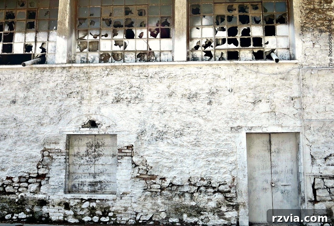 Stone Chronicles of the Shore 9 A whitewashed old building showing signs of crumbling, depicting the slow decay of waterfront stone architecture. Image by www.theboondocksblog.com