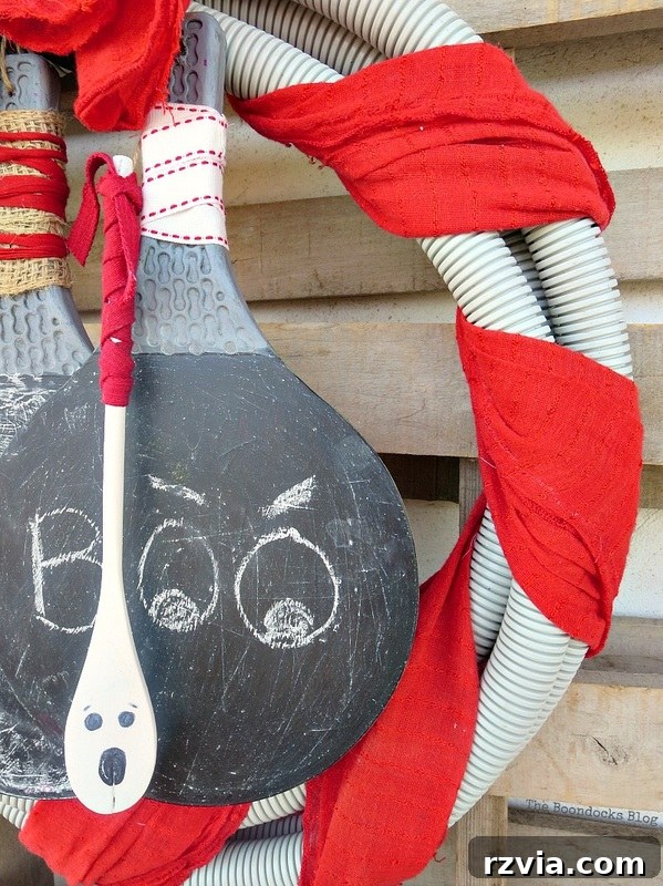 Transform Tubes into a Halloween Wreath 16 A 'Boo' sign, adding a classic Halloween greeting to the festive decor.