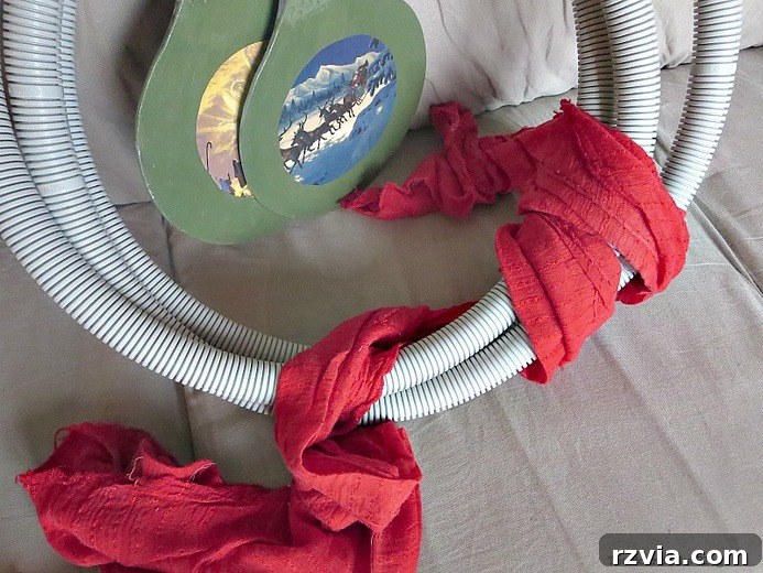 Transform Tubes into a Halloween Wreath 6 Red fabric being meticulously wrapped around the tube base of the Halloween wreath.