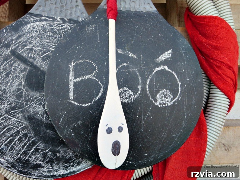 Transform Tubes into a Halloween Wreath 10 A close-up view of the ghost spoon decoration, featuring its painted face and red ribbon.