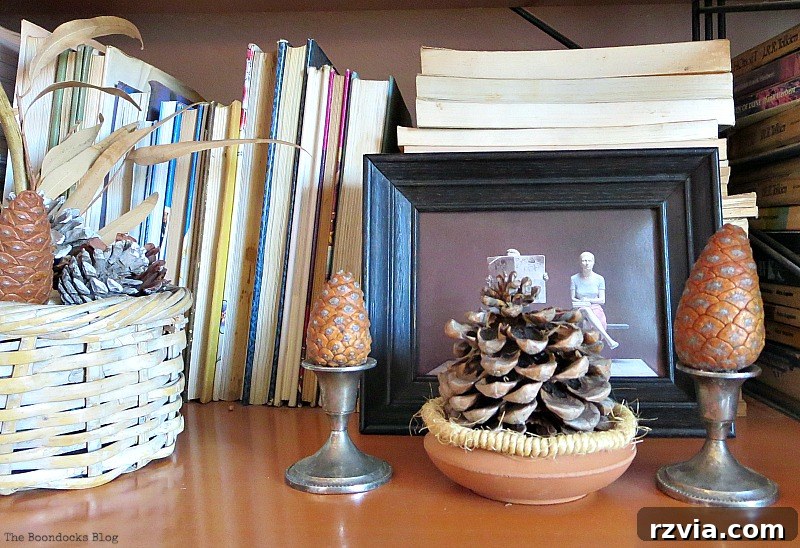Black framed image and pinecones, enhancing the natural and mysterious feel of the Halloween Wall Unit Decor.