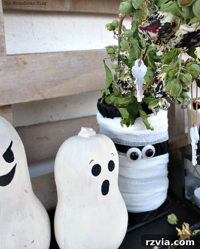 Gourds and mummy under a branch with keys hanging from it, unique Halloween display