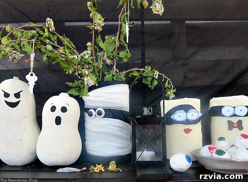 A collection of painted gourds, and tin mummies for DIY Halloween decor
