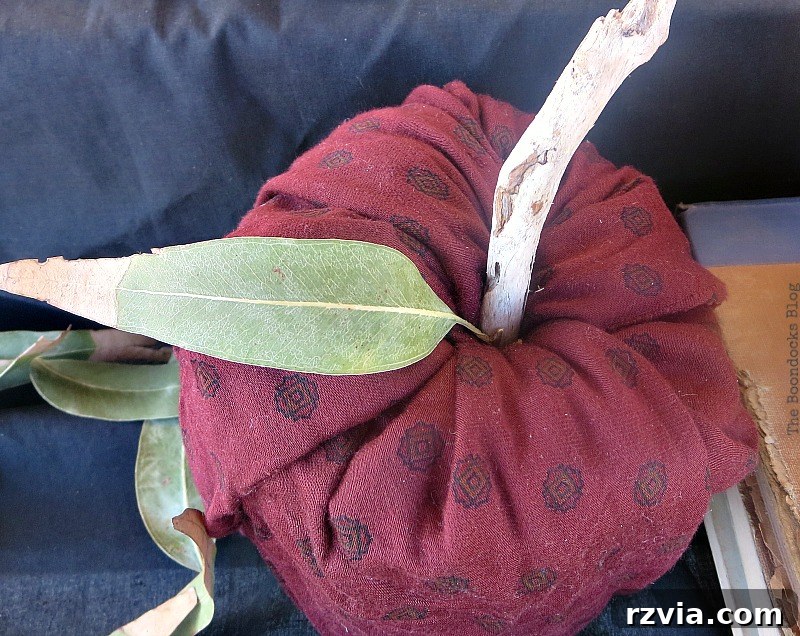 Crafting the Paranoid Pumpkin Man 9 A pumpkin made with scrap fabric, driftwood, and dried leaves, contributing to the fall vignette in 'The Paranoid Man Pumpkin Craft,' from www.theboondocksblog.com