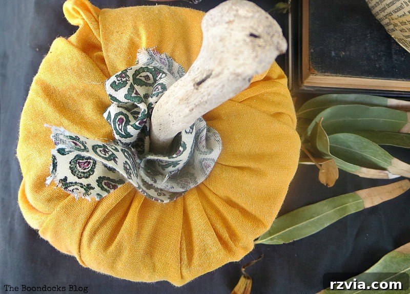 Crafting the Paranoid Pumpkin Man 13 Close-up of a toilet paper roll covered in fabric, demonstrating a DIY pumpkin technique in 'The Paranoid Man Pumpkin Craft,' from www.theboondocksblog.com