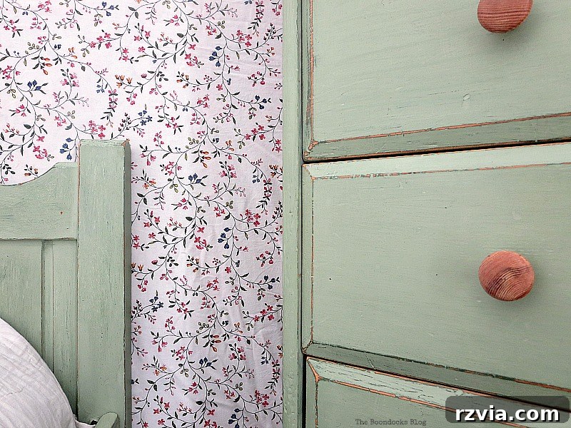 Headboard of the renovated bed frame positioned beside the green dresser, highlighting the perfectly matched bedroom furniture.
