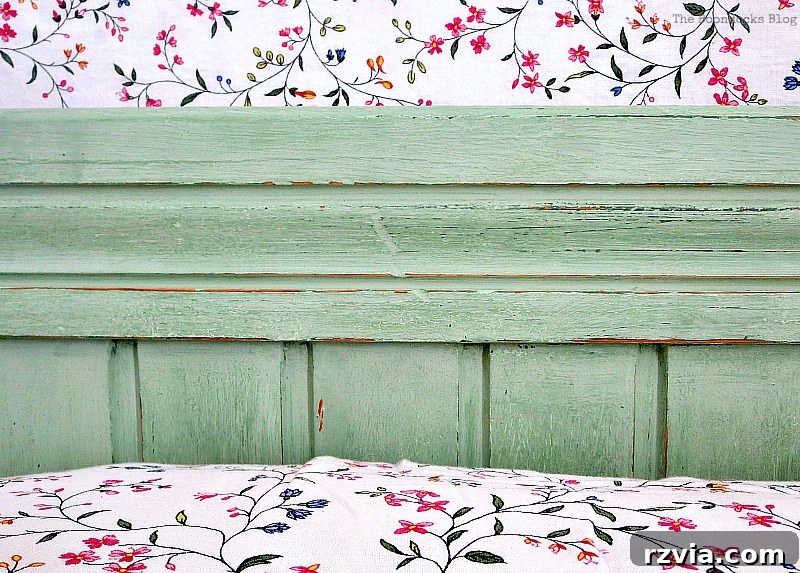 Detailed shot of the center of the headboard, revealing the intricate distressing and layered paint colors that add depth.